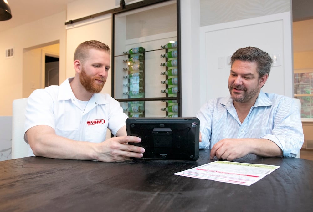 HVAC technician discussing completed furnace installation with homeowner – Hoffmann Brothers