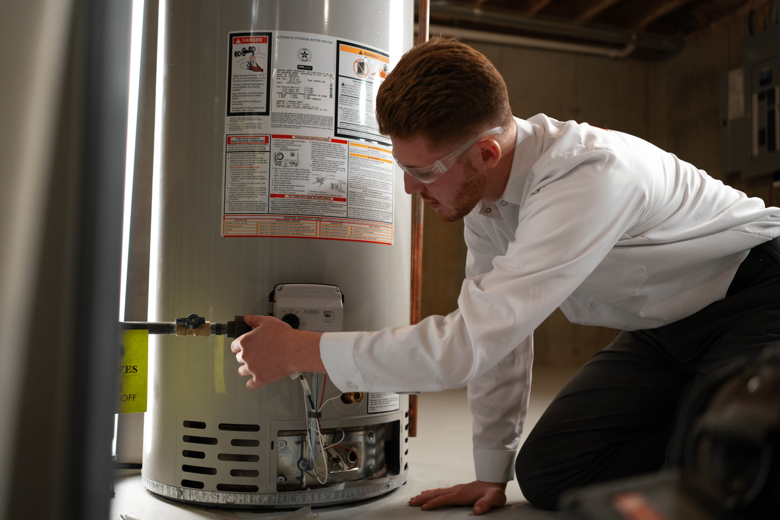 Water heater professional inspecting tank water heater unit before replacement