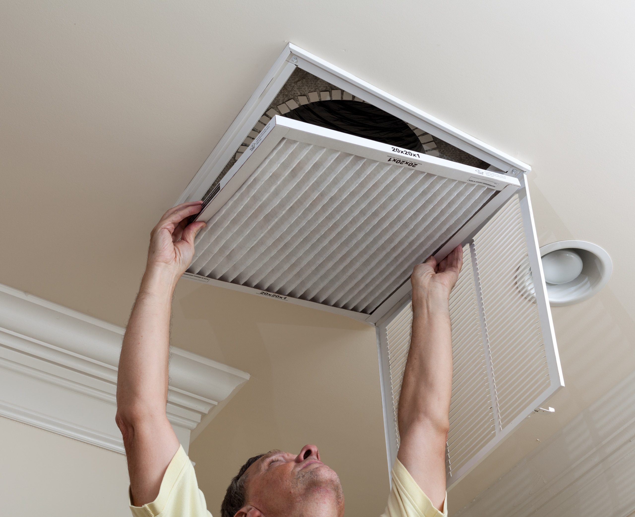 Person replacing and HVAC filter to ensure better indoor air quality