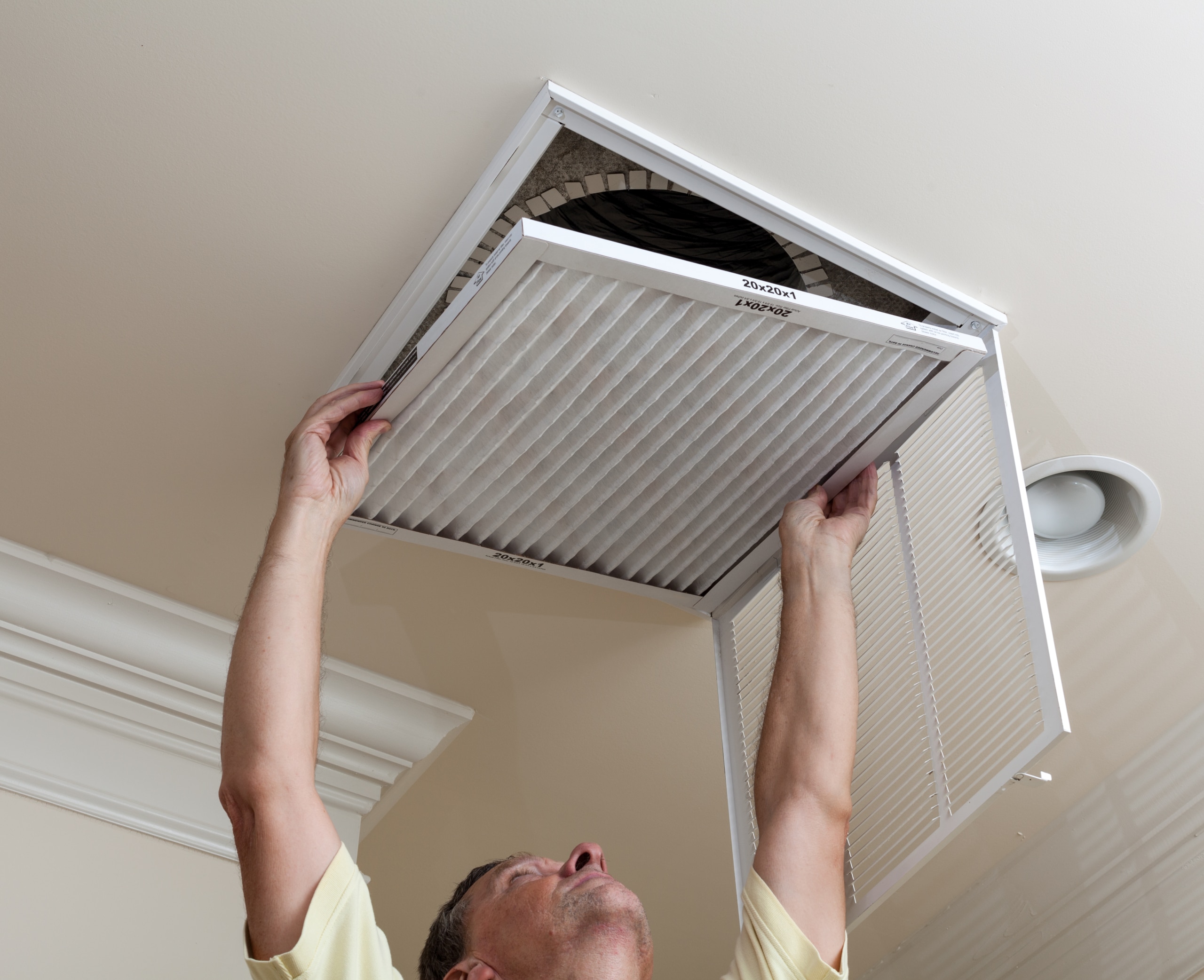 Person replacing and HVAC filter to ensure better indoor air quality 